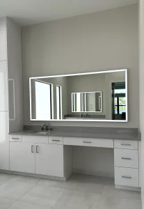 Modern LED-lit glass mirror enhances bathroom decor and lighting.