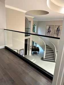 Stylish glass and metal railing enhances staircase safety and aesthetics.