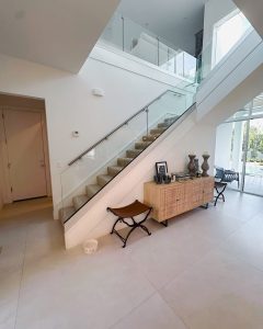 Light-filled contemporary home with elegant glass staircase and minimalist decor.