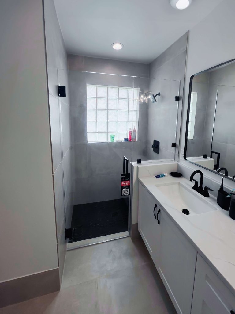 High-quality glass shower enclosure with modern black hardware.