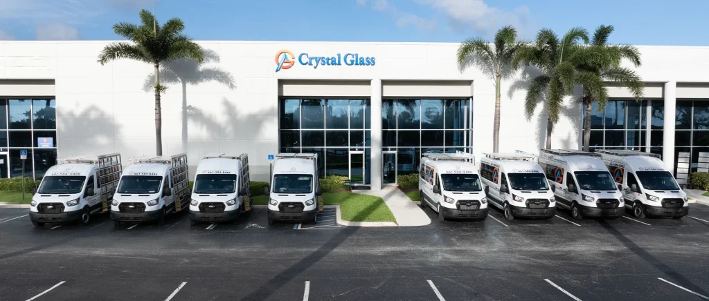ACG Glass & Metals building with parked service vans and palm trees.