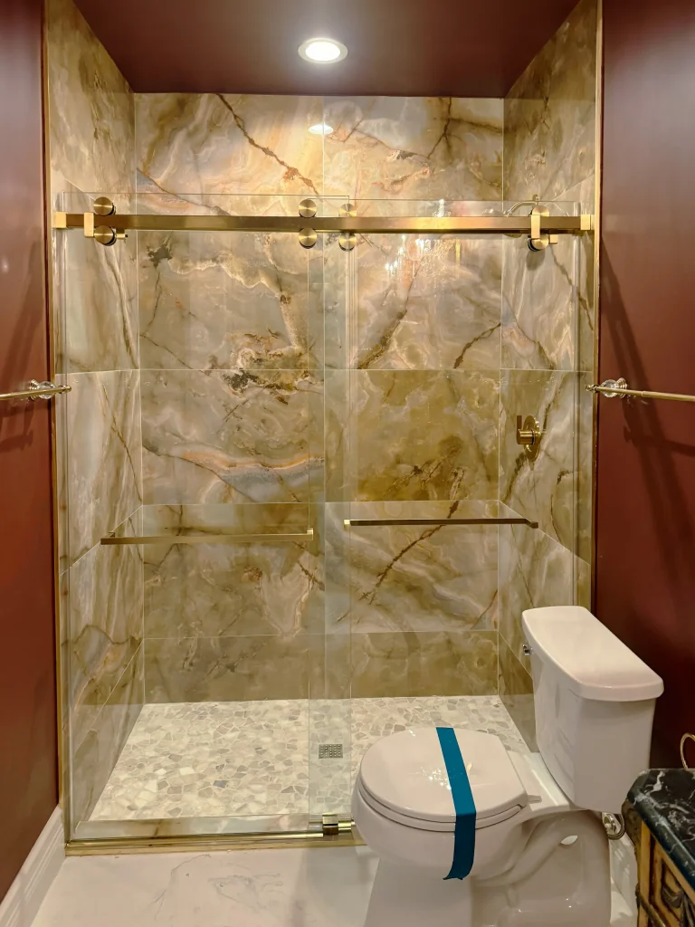 High-quality glass shower door with marble interior for luxury bathroom design.