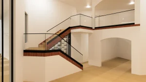 Stunning modern staircase featuring glass balustrades and sleek wooden accents for stylish home design.