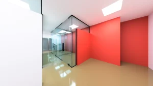 Clear glass doors with black handles in a stylish office space featuring vibrant red walls.