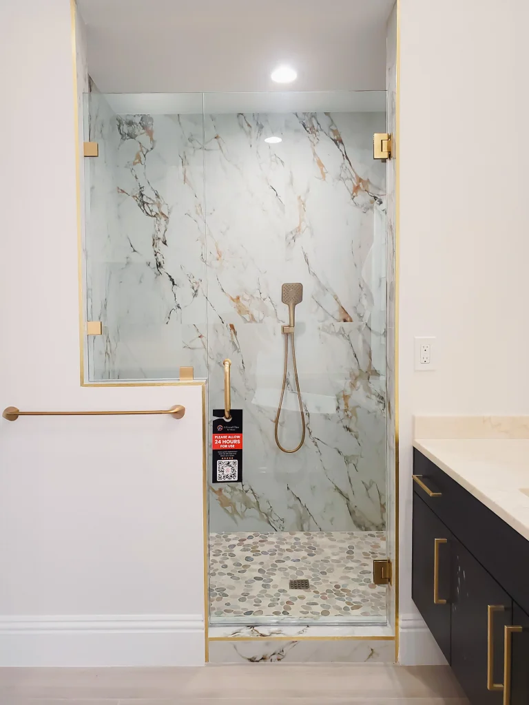 High-quality marble shower glass enclosure with gold accents for luxurious bathroom design.
