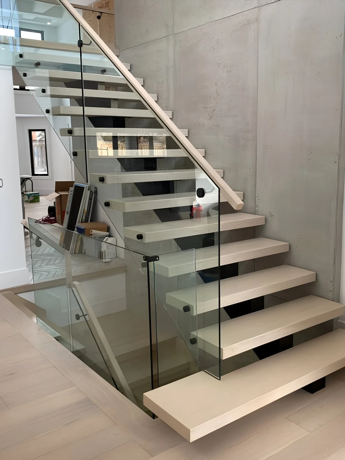 Floating staircase with wood treads and glass railing by ACG Glass & Metals