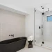 Alt text: Sleek glass shower with modern fixtures and black accents in contemporary bathroom.