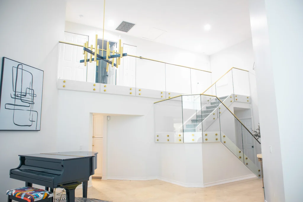 Elegant glass stair rail with gold accents and sleek black handrail.