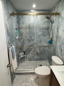 High-quality glass shower with sleek hardware and marble wall tiles for a luxurious bathroom look.