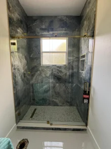 Luxury glass shower with marble tiles and gold hardware, modern bathroom upgrade.