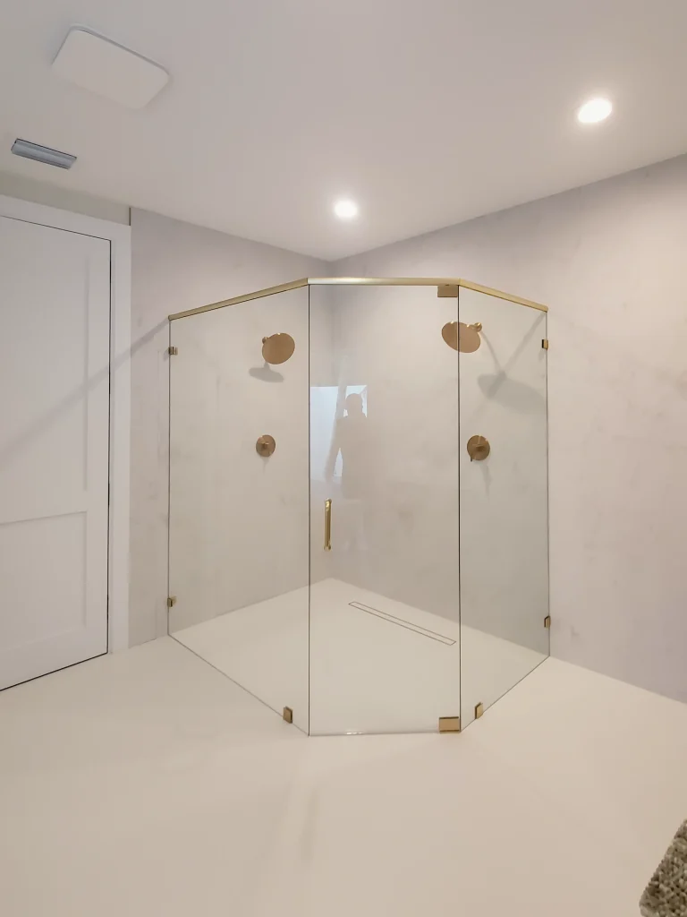 High-quality glass shower with gold accents, modern design, and seamless transparency.