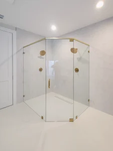 Custom glass shower with brass accents and clear panels for a modern bathroom look.