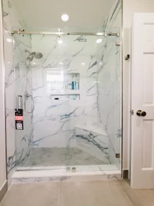 High-quality glass shower door with marble walls and sleek fixtures.