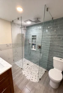 Sturdy frameless glass shower enclosure with modern green tile accents.