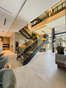 Elegant modern interior with glass staircase and mirrors.