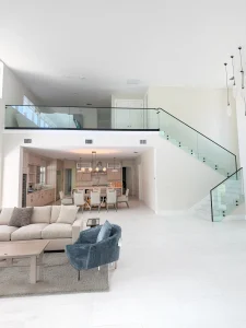 Stunning modern interior with glass staircase and sleek glass railing design.
