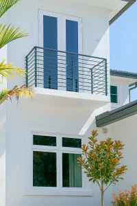 Stylish glass balcony railing with sleek metal supports on a contemporary home.