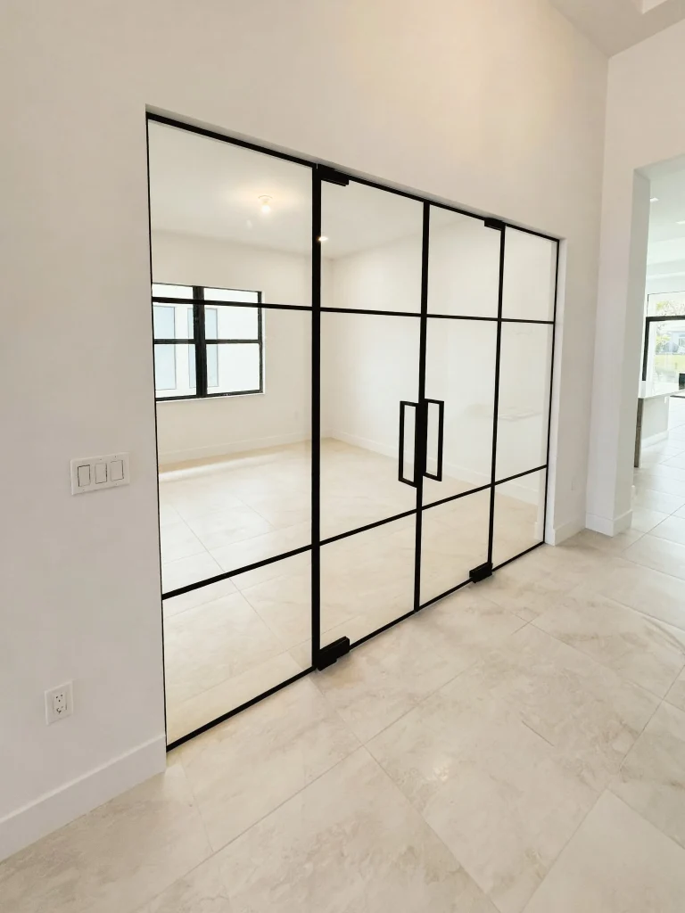 Beautiful glass and mirror sliding door with black metal frame enhances contemporary home spaces.