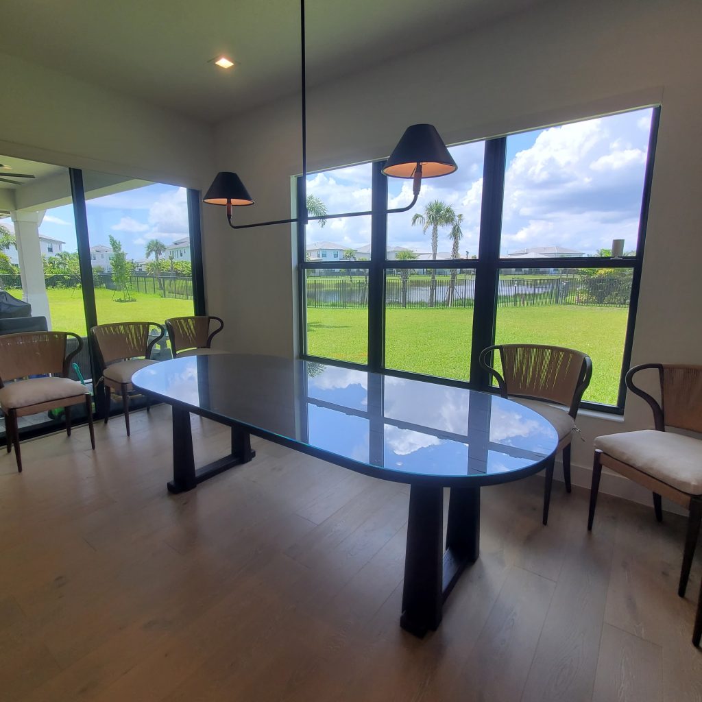 Sharp, clear glass dining table perfect for modern homes, with stylish wooden chairs and ample natural light.