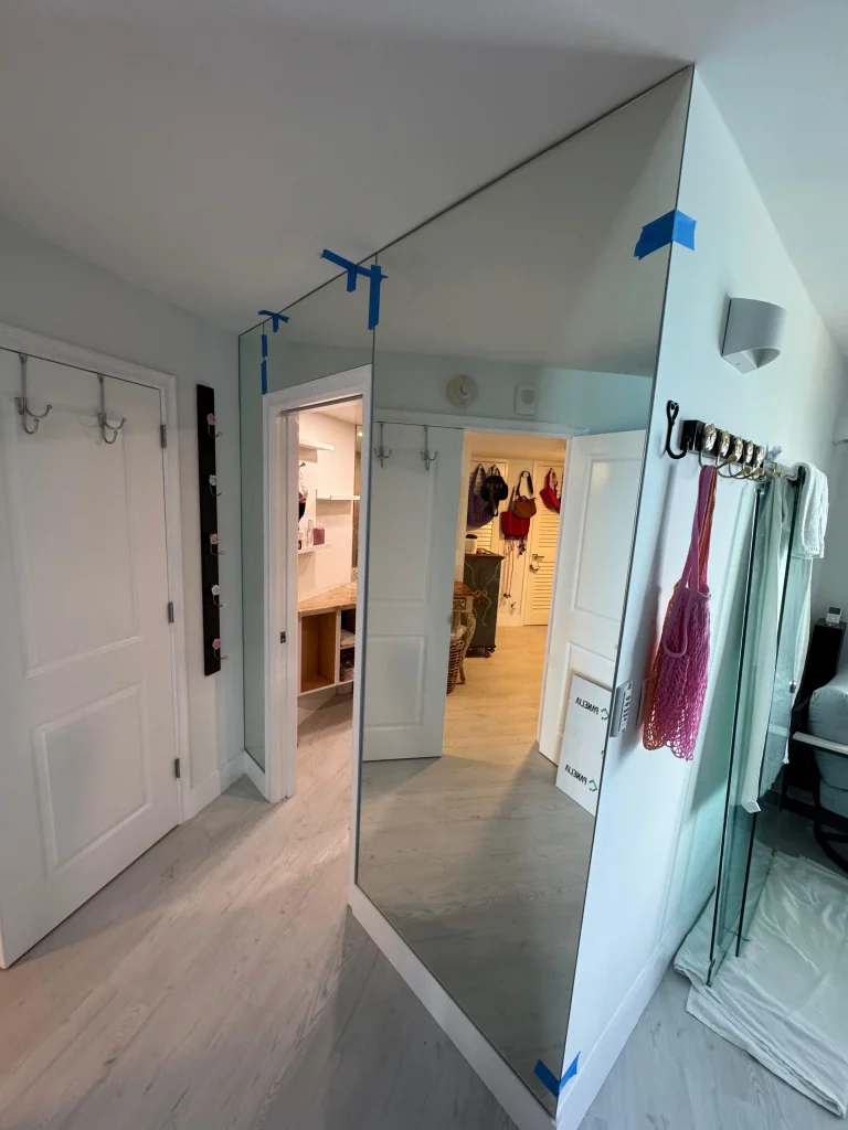 Large decorative mirror with sleek edges in a contemporary bedroom.