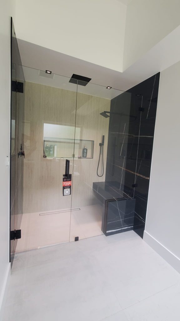 Luxury glass shower door with black framing and minimalist design, ideal for contemporary bathrooms.