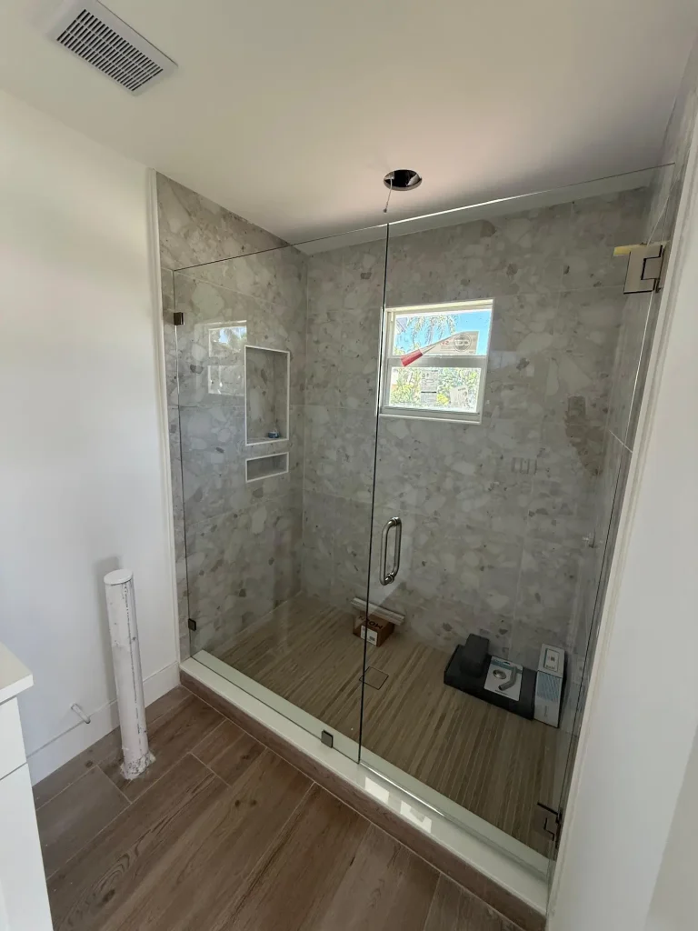 Bathroom shower enclosure with clear glass, modern design, and elegant tilework.
