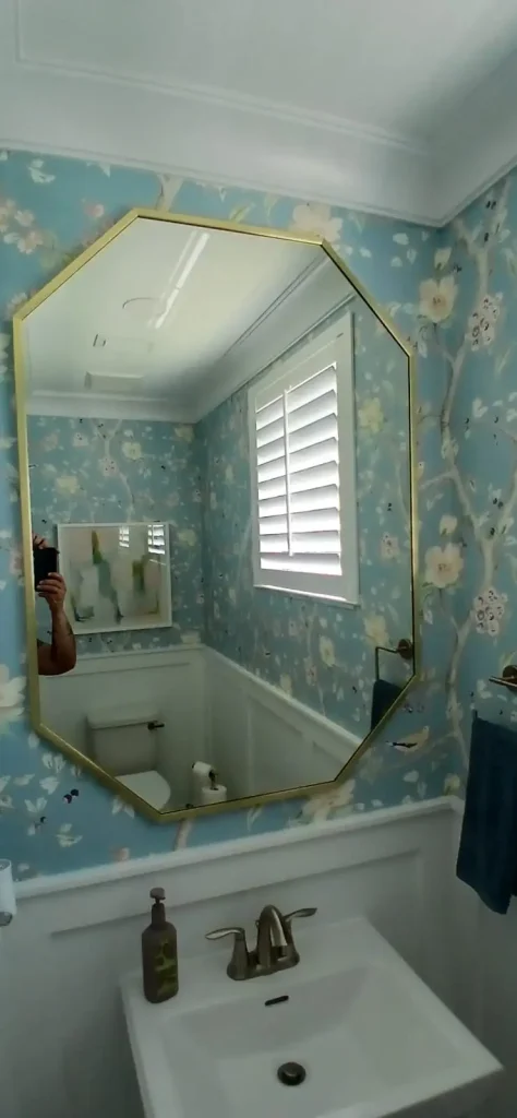 Elegant bathroom mirror featuring a stylish gold frame, enhancing interior decor.
