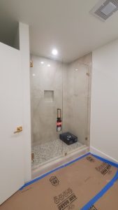 Clear glass shower door with sleek handle and modern design.