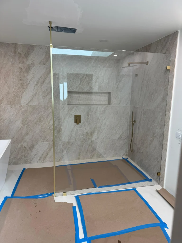 High-quality glass shower door with modern design and gold accents.