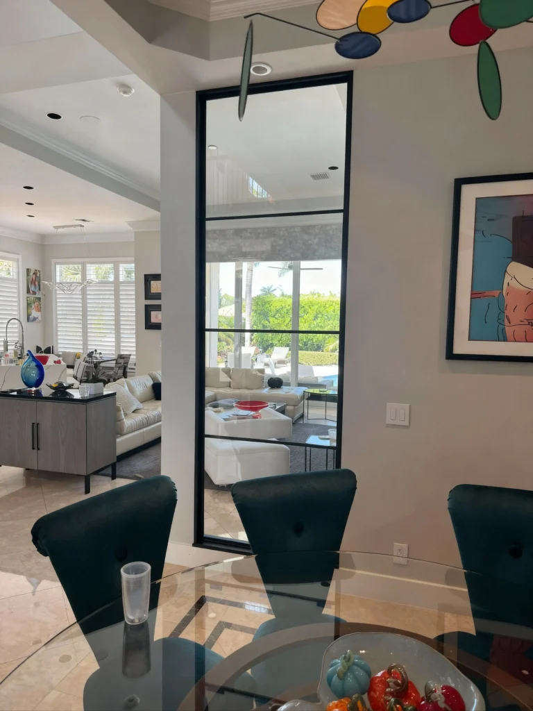 High-quality glass room divider with sleek black frame enhances interior space.
