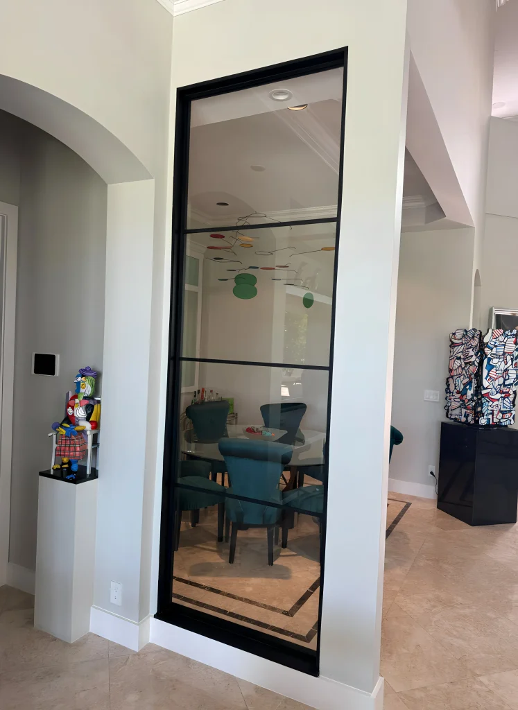 Reflective glass interior door with black frame, stylish modern design.