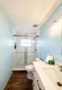 Elegant bathroom featuring glass shower, modern sink, and stylish tile accents.