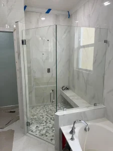 Clear glass shower door with stainless steel handle.
