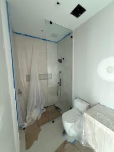 High-quality glass shower door with modern black fixtures, seamless design for luxury bathrooms.