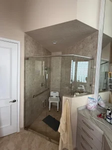Bright, modern bathroom with custom glass shower door and marble accents.