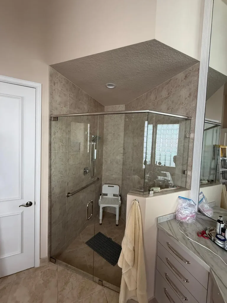 Bright, modern bathroom with custom glass shower door and marble accents.