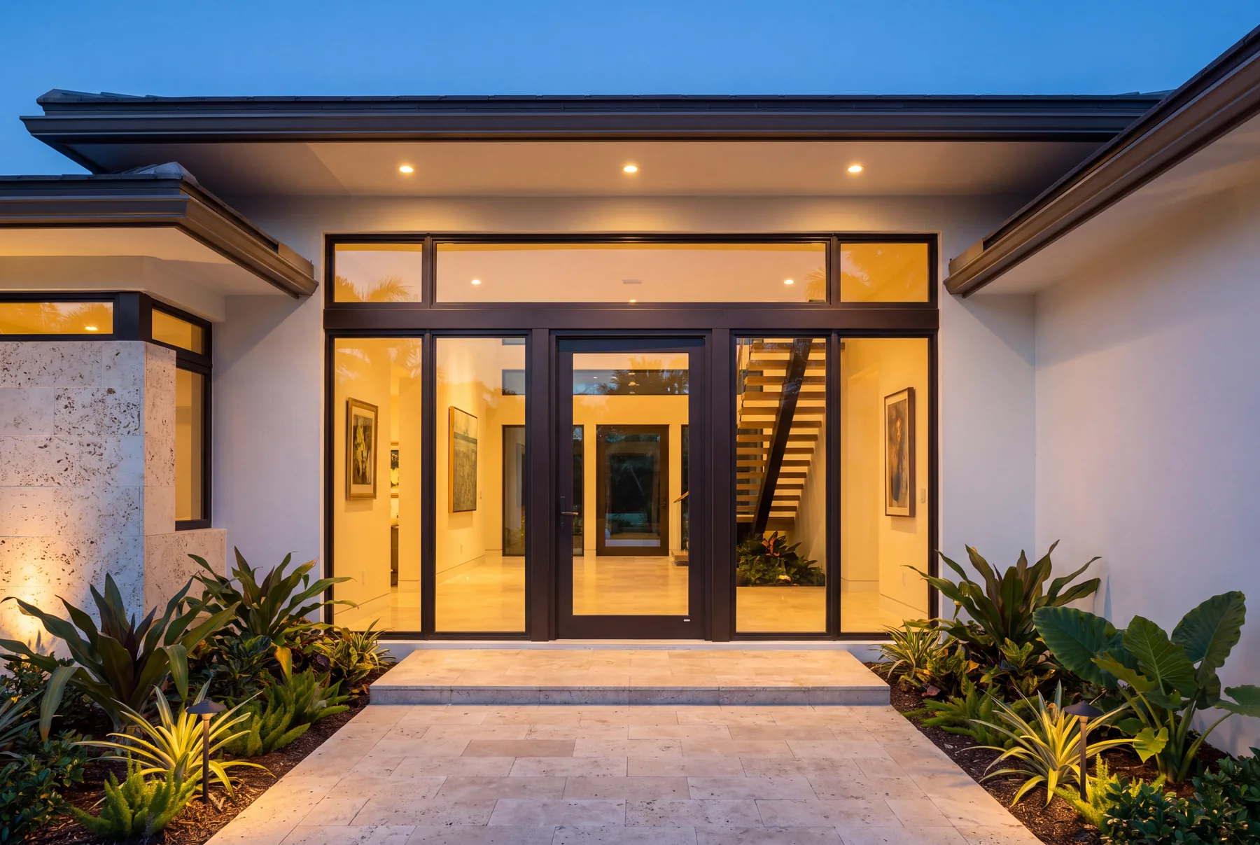 Residential entry glazed as one continuous run of aluminum storefront framing with matching sidelites and a transom
