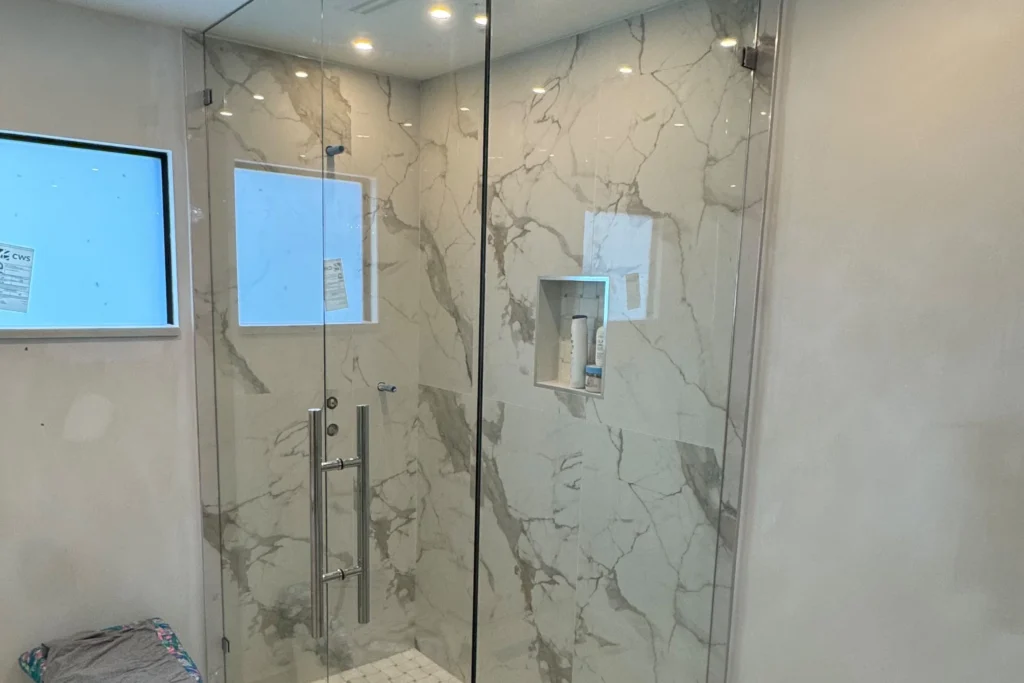 Frameless clear glass shower enclosure with polished chrome hardware in a 126th Terrace North residence, Jupiter, FL