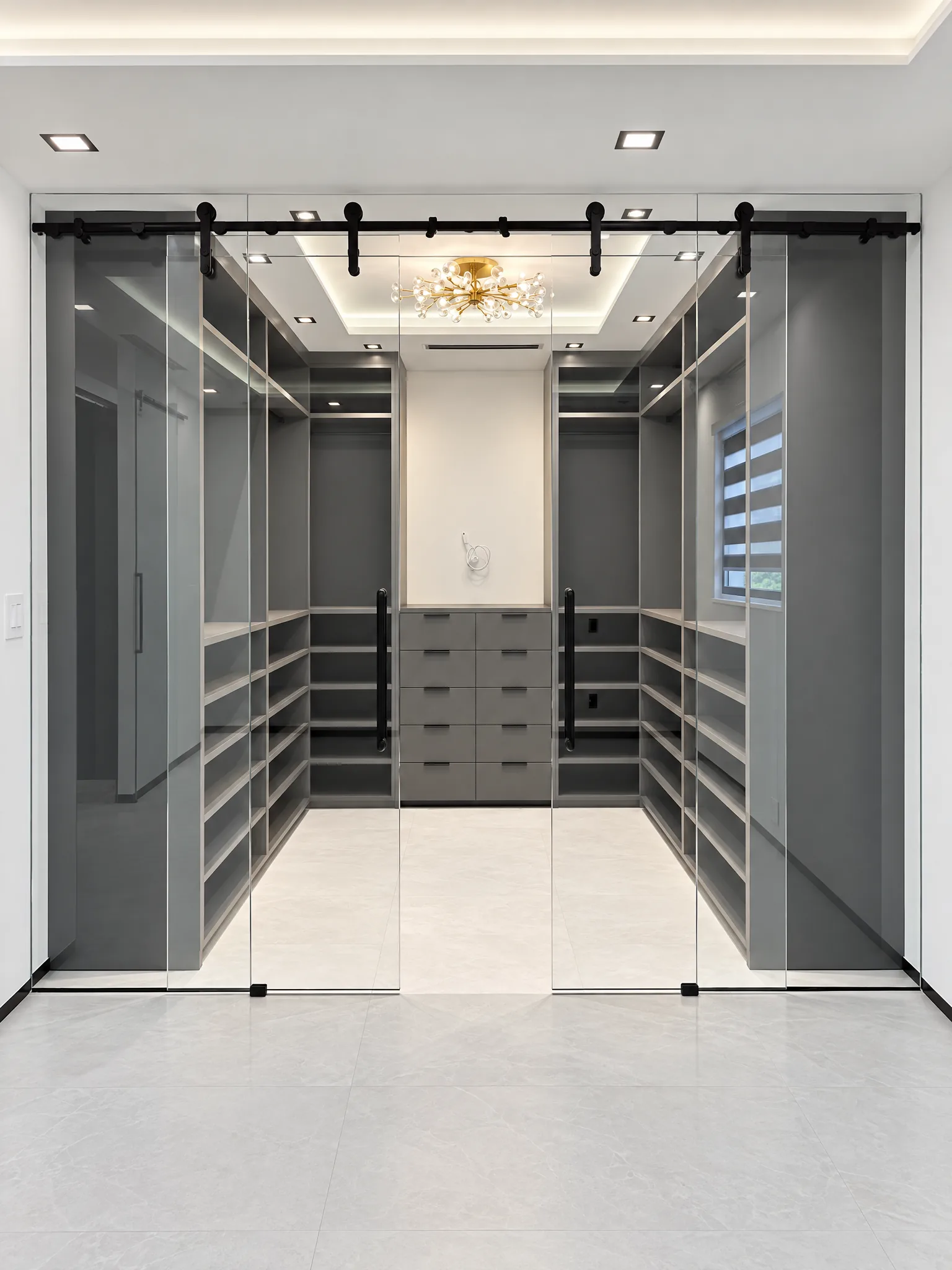 Frameless glass barn doors in front of a walk-in closet