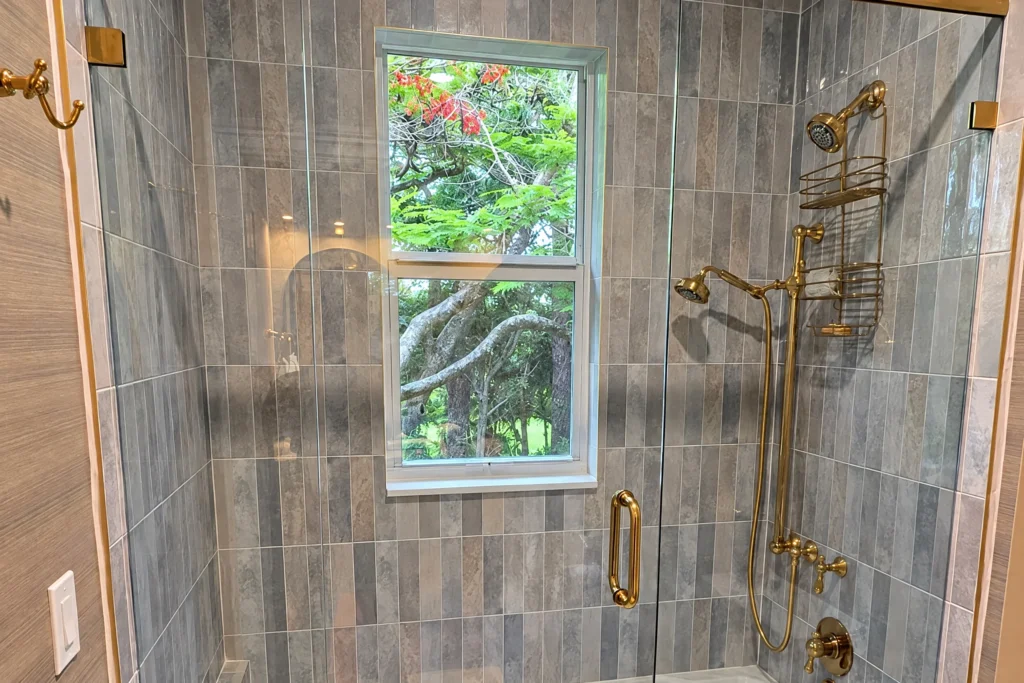 Brass hardware frameless glass shower enclosure in a West Palm Beach residence by ACG Glass & Metals