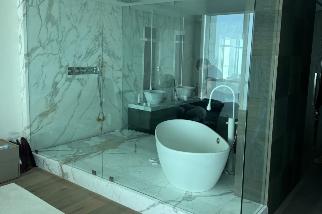 Frameless glass shower enclosure at the Collins Avenue residence in Bal Harbour, FL