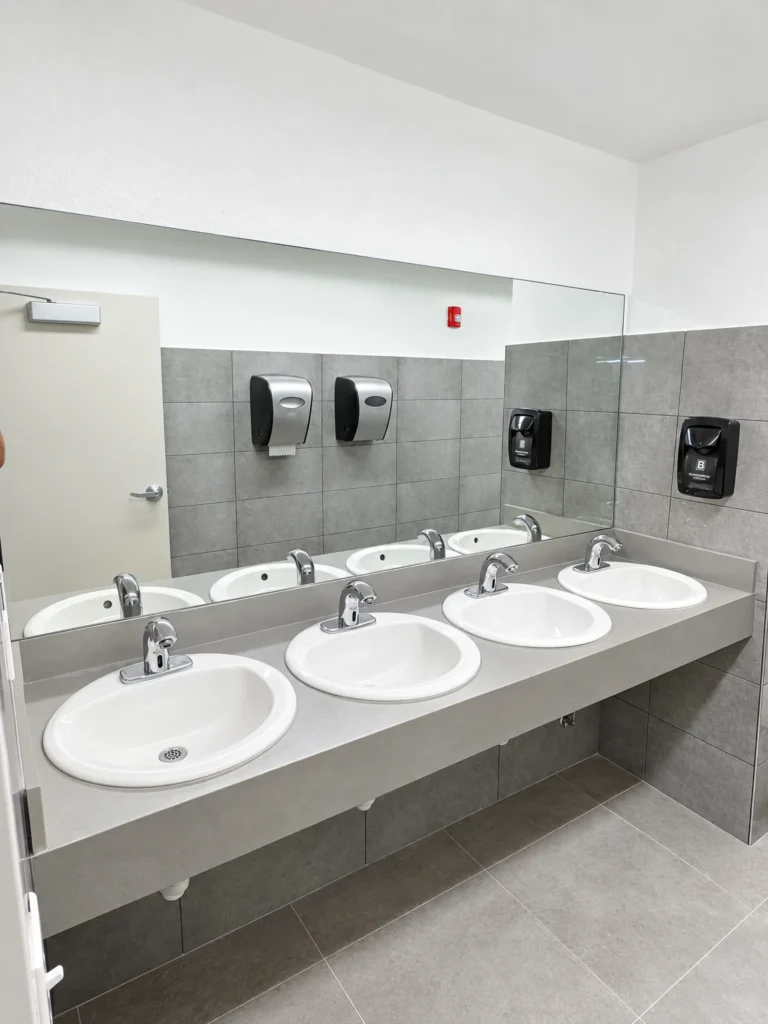 Wall-to-wall restroom mirror over a multi-sink counter, Bridge Prep Academy Green Village, Miami