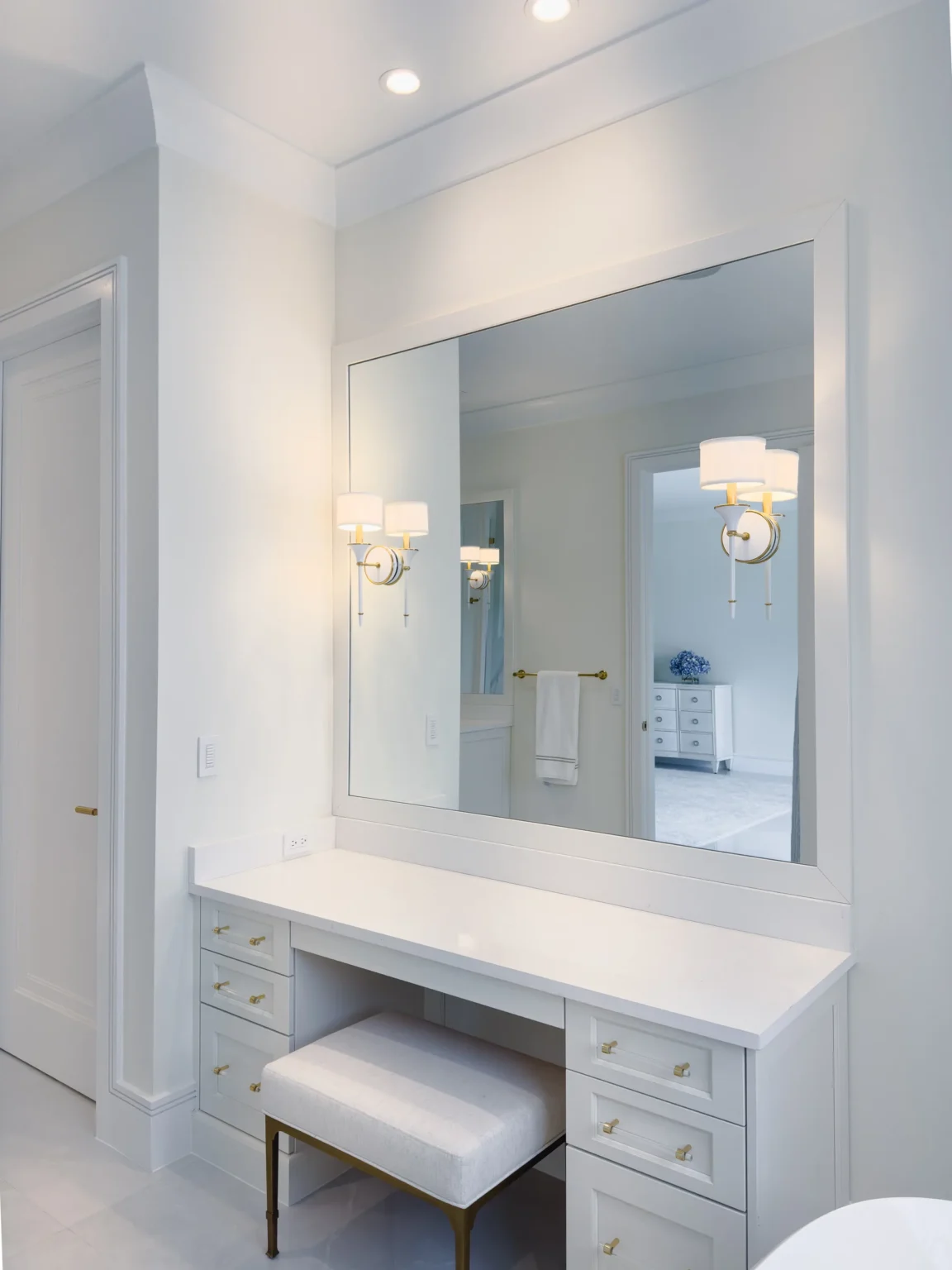 Frameless vanity mirror with a polished edge over a makeup desk, installed by ACG Glass & Metals