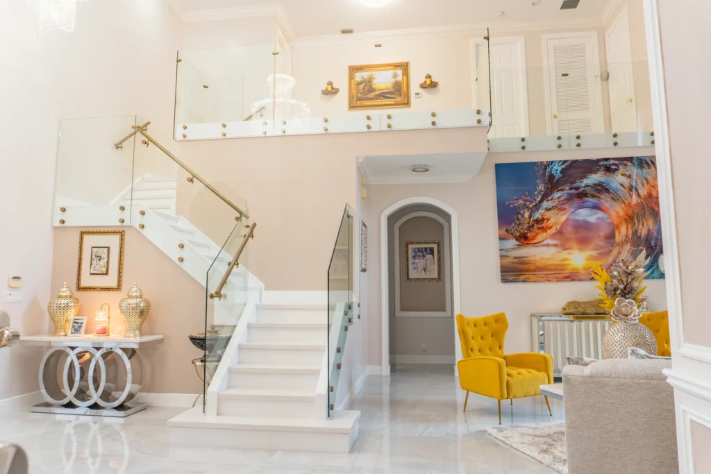 Two story foyer with frameless glass stair and landing railings and satin brass handrails, West Palm Beach