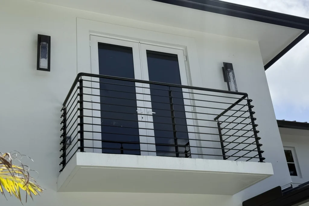 Powder-coated horizontal rod railing with square posts on a second-floor balcony in West Palm Beach