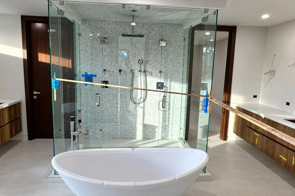 Frameless glass shower enclosure at the Isle of Palms Drive residence in Fort Lauderdale, FL