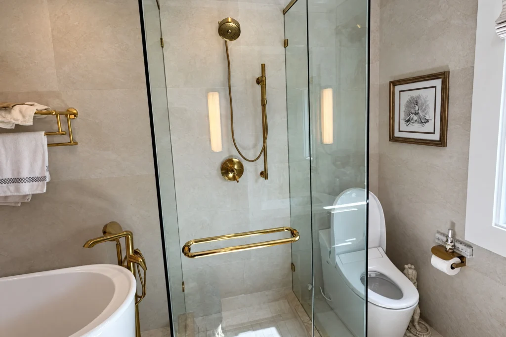 Frameless glass shower enclosure with satin brass hardware by ACG Glass & Metals in Palm Beach