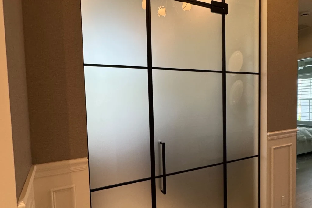Acid etched low iron glass office partition with black grid and swing door, Palm Beach Gardens FL