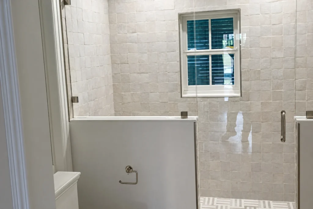 Frameless glass shower enclosure with clear tempered glass in a North Beach Road residence, Hobe Sound