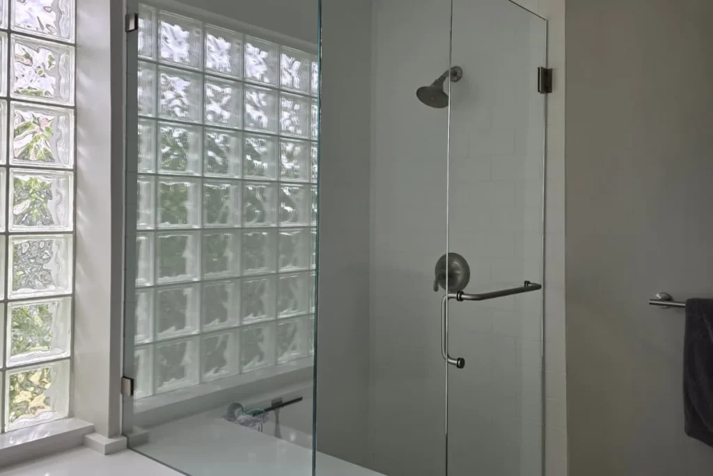Frameless glass shower enclosure with brushed nickel hardware, Oyster Road residence, North Palm Beach
